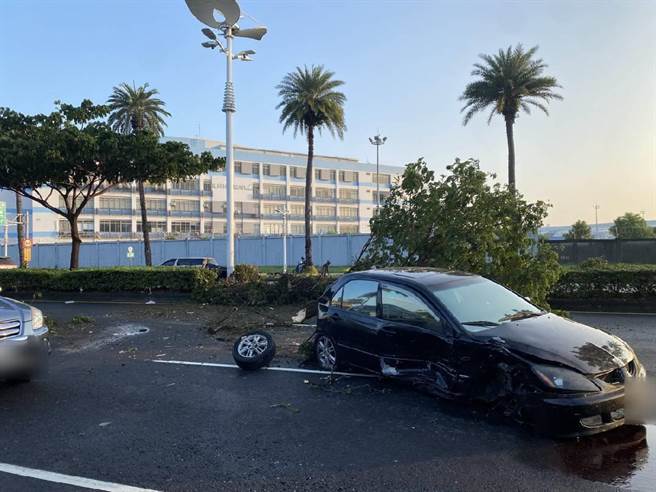 高市小港區今天上午發生一起車禍，黑色小客車和另1輛自小客擦撞，撞倒路樹後，右前方車輪滾落、車門凹陷。（翻攝照片／石秀華高雄傳真）