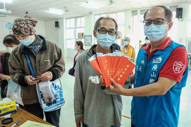 领到9千元纾困金的民眾高兴的跟乡长张志弘（右）说，可以买1个月的猪肉。（罗浚滨摄）