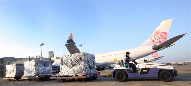 地勤人員將3個裝載疫苗的冷凍貨櫃運往華儲倉庫。（范揚光攝）