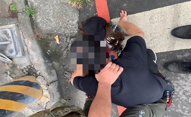 刘男走到机车旁脱下了「长卷髮」，立刻被警方认出身分并捕获。（台中市警察局提供／张妍溱台中传真）