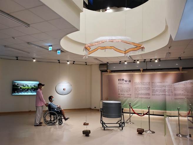 雲嘉嘉營視覺藝術連線的「移動聚落」主題展目前在雲林縣文觀處展覽廳展出，裝置藝術家林正偉以薄紙與電扇創造出「交託給風」，看似阿拉丁魔毯隨風飛起，一名來自東南亞就醫中的的移工看得很專注。（周麗蘭攝）