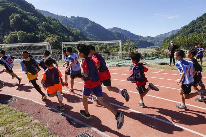 參加兩公里路跑競賽學童在群山環繞的操場跑道衝刺前進。（黃子明攝）