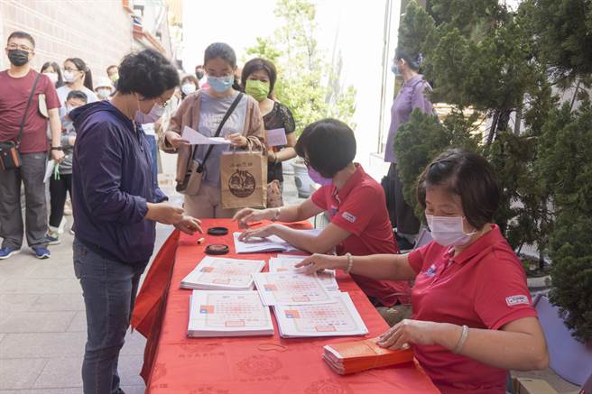 万和宫诵经团志工亲切为领取奖学金的同学与家长服务。（万和宫提供）