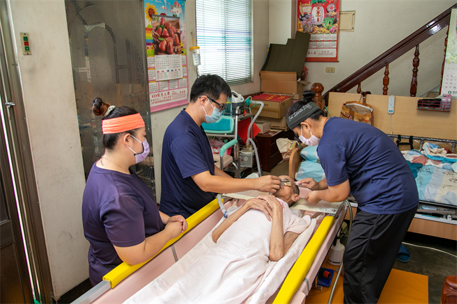 装着呼吸器的刘爷爷接受到宅沐浴之前，担心呼吸器掉落只能用擦澡替代。（永信社会福利基金会提供）