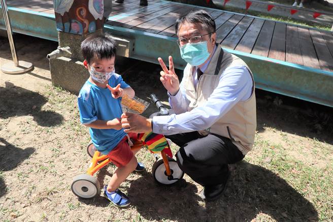 台南市总爷艺文中心6日举行开馆20周年庆祝活动，市长黄伟哲(右)发送小火车画糖给小朋友。(刘秀芬摄)