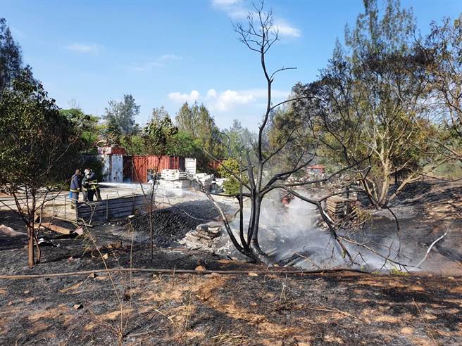 金门欧厝战备道今天下午突起无名火，烧毁堆置杂草旁的建材，县消防局出动7车20人赶往灌救。（金门县消防局提供）