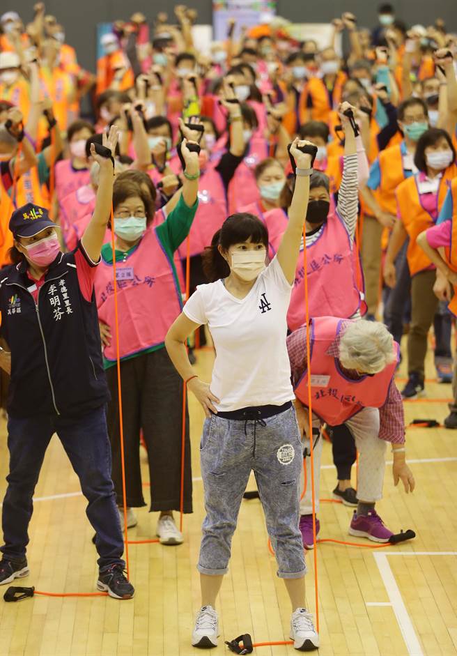 來自各行政區的精英銀髮族選手一起用彈力繩做暖身運動。（季志翔攝）