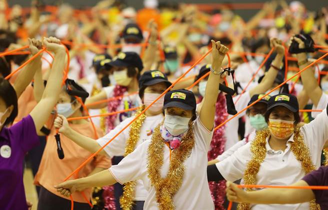 來自各行政區的精英銀髮族選手一起用彈力繩做暖身運動。（季志翔攝）