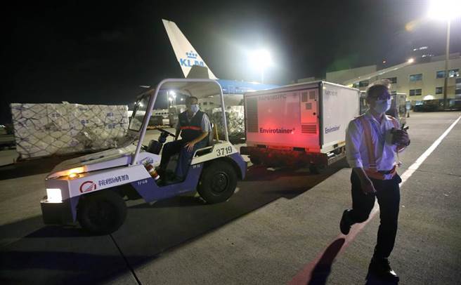 班機停妥後地勤人員將裝載疫苗的冷凍貨櫃卸下。（范揚光攝）
