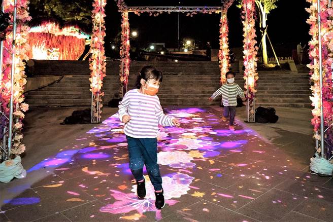 KANO展区广场中间的「春绽步道」更是吸睛，走入其中可感受到春天的氛围，更新奇有趣的是地面的互动投影，以银河星空为背景，大小朋友只要挥挥手、动动脚、跑跑跳跳就会呈现绽放的花朵。（嘉义市政府提供∕吕妍庭嘉义传真）