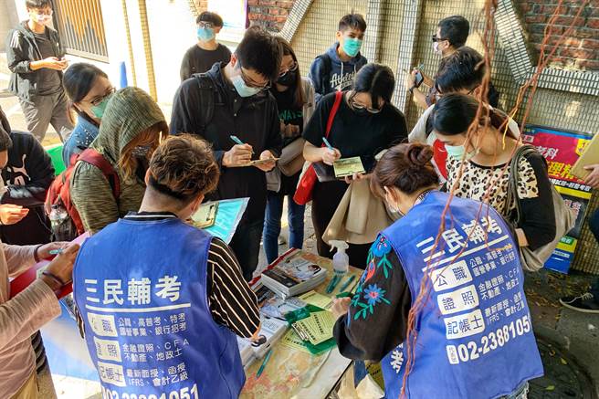 经济部所属国营事业台糖、台电、台湾中油及台水今天举行新进职员甄试。中午休息时间，公职补习班业者在考场招徕考生。（邓博仁摄）