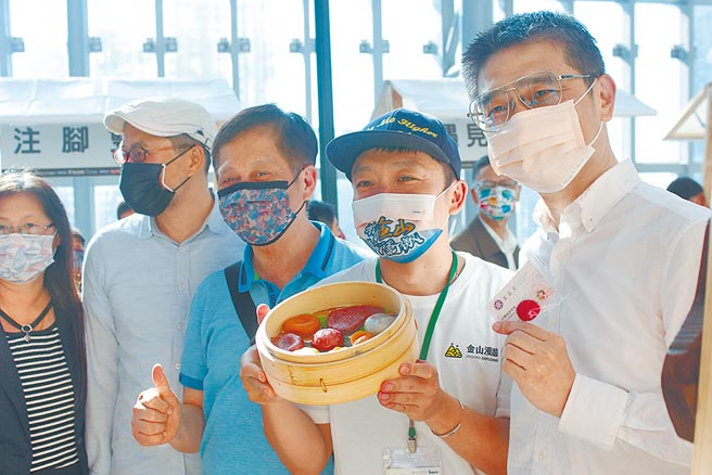 参与农创体验市集的金山萝卜糕名店「富品家」负责人李东展（右二）与农业局长李玟（右一）畅谈农创心路歷程。（陈慰慈摄）