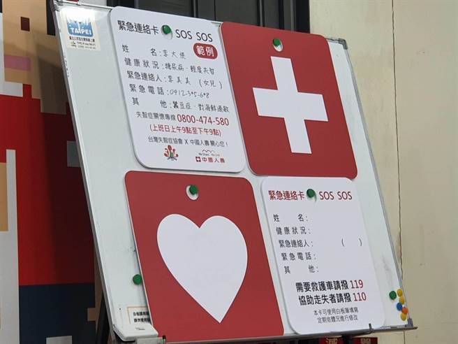 紧急连络卡前后图案为十字与爱心，内容包含配戴者姓名、病史、紧急连络人电话等。（陈人齐摄）