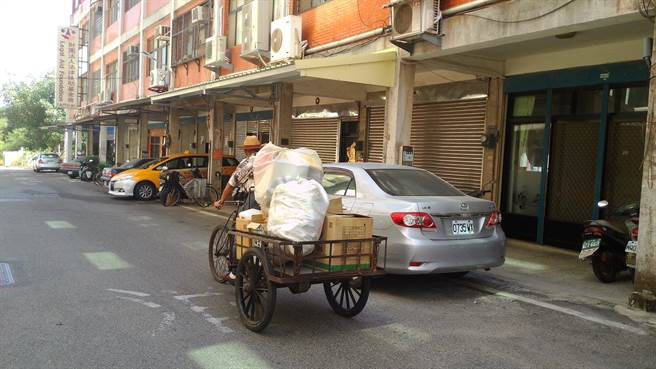老阿公黄登坚踩着资源回收三轮车，走过金门后浦城区街头。（金门县环保局提供）