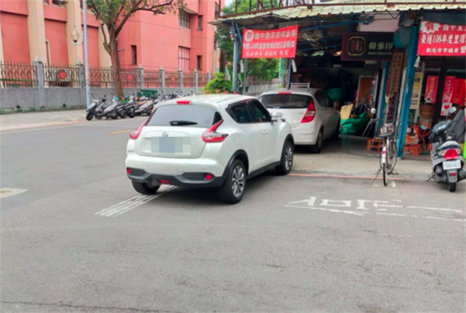 網友發現板橋某里長將轎車以「離譜」方式停在住家門口，照片中該里長的轎車就直插在一處三角窗店面前，全部車身幾乎都在柏油路上，明顯已阻礙交通。（翻攝自臉書「爆料公社」）
