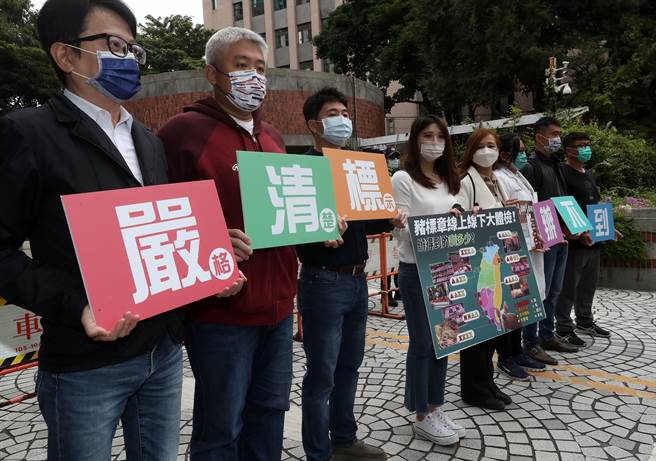 民間團體「反萊豬．大眾走」聯盟召集人陳思宇（左四）號召全台8個縣市的在地觀察員10日在農委會大門前舉行記者會，揭露「鬆散的標示辦法」、「民眾對稽查的不信任」、「疊床架屋的貼紙」等5大台灣豬標章的亂象，大家拿著標語，喊出「嚴（格）、清（楚）、標（示）」的訴求，希望政府負起把關豬肉及豬肉製品來源的責任，守護人民的食安及保護國產豬。（劉宗龍攝）