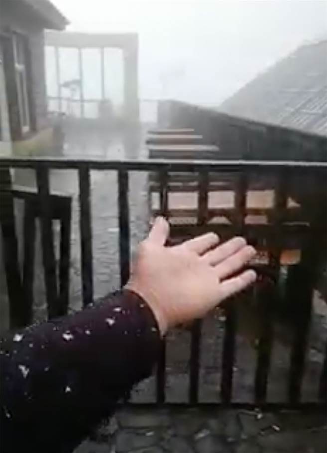 受东北季风湿冷天气影响下，合欢山10日上午7点多降下冰霰，上山追雪民眾，开心伸手感受那轻飘飘的「雪」。（脸书「臺湾追雪团」提供／黄国峰南投传真）