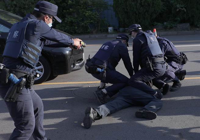 台北捷运车厢突发状况模拟演练，在捷运站外演练遇见遭遇拦查闯红灯民眾暴力模拟案例，在喷洒辣椒水无效后，再由警方使用「抛射式电击器」制伏暴力民眾。（郑任南摄） 