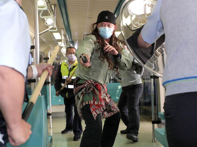 台北捷运车厢突发状况模拟演练，在捷运内发生持刀民眾随机杀人暴力事件，员警赶到现场接手捷运安全人员，使用辣椒水与「抛射式电击器」制伏暴力民眾。（郑任南摄） 