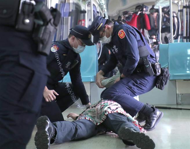 台北捷运车厢突发状况模拟演练，在捷运内发生持刀民眾随机杀人暴力事件，员警赶到现场接手捷运安全人员，使用辣椒水与「抛射式电击器」制伏暴力民眾。（郑任南摄） 