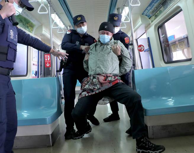 台北捷运车厢突发状况模拟演练，在捷运内发生持刀民眾随机杀人暴力事件，员警赶到现场接手捷运安全人员，使用辣椒水与「抛射式电击器」制伏暴力民眾。（郑任南摄） 