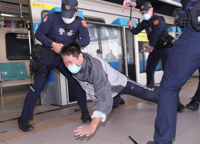 台北捷运车厢突发状况模拟演练，在捷运内发生民眾持汽油欲轻生伤害乘客时暴力事件，员警赶到现场接手捷运安全人员，喷洒辣椒水并制伏欲轻生民眾。（郑任南摄） 