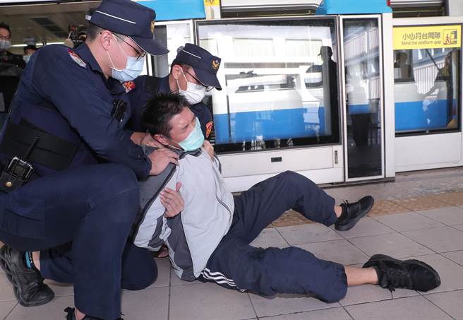 台北捷运车厢突发状况模拟演练，在捷运内发生民眾持汽油欲轻生伤害乘客时暴力事件，员警赶到现场接手捷运安全人员，喷洒辣椒水并制伏欲轻生民眾。（郑任南摄） 