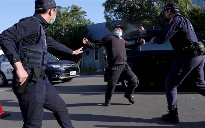 台北捷运车厢突发状况模拟演练，在捷运站外演练遇见遭遇拦查闯红灯民眾暴力模拟案例，在喷洒辣椒水无效后，再由警方使用「抛射式电击器」制伏暴力民眾。（郑任南摄）