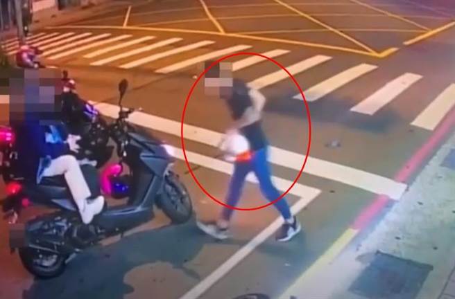 騎車雙載的男女闖紅燈，被路人好心提醒後，男子竟暴打路人，女生則全程坐在機車上觀看。(翻攝自影片)