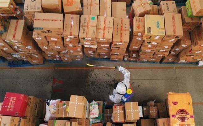 菜鸟网络石家庄公共分拨中心工作人员在对快递包裹进行消毒作业。（新华社）