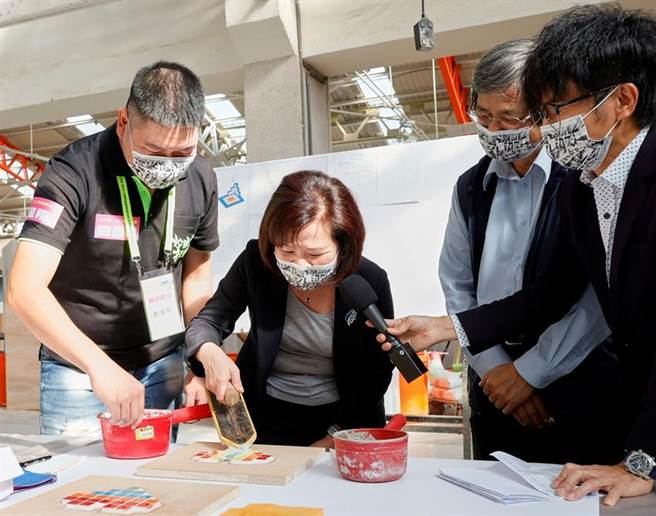 （劳动部部长许铭春体验爱心造型磁砖贴画。图／劳动部提供）
