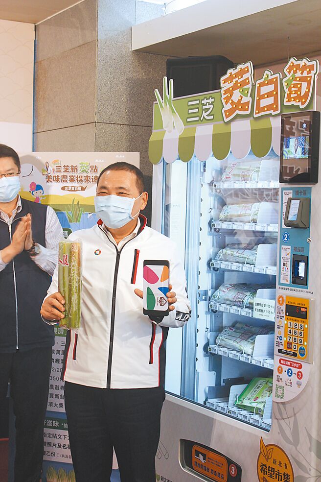 新北市长侯友宜示范如何利用行动支付购买茭白笋产品。（陈慰慈摄）