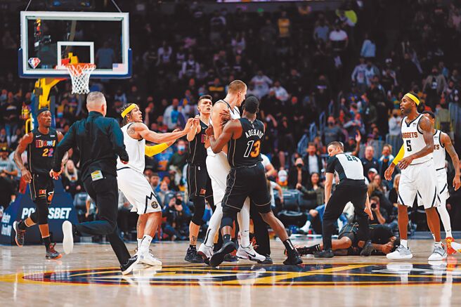 金塊中鋒約基奇（中）推倒熱火的馬基夫莫里斯（右下倒地者）之後，被兩名熱火球員架開。（路透）