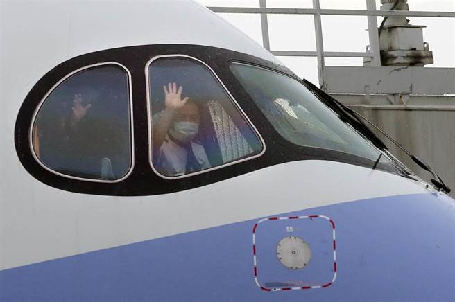 班機停妥機坪後，機師向地勤人員揮手致意。（范揚光攝）

