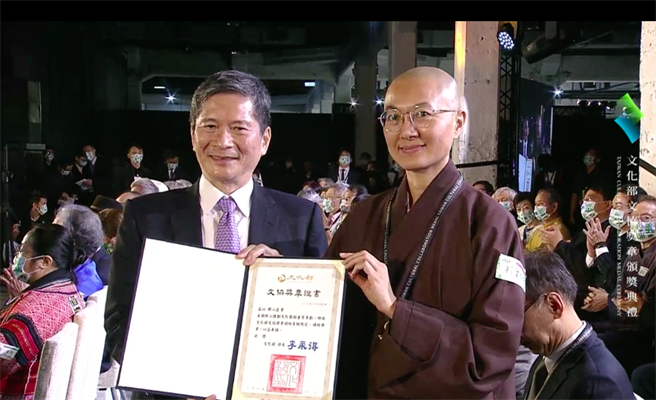 心道法师获得首届文协奖章，由宝祥法师代表出席颁奖典礼，接受文化部长李永得颁发的证书。（文化部提供）