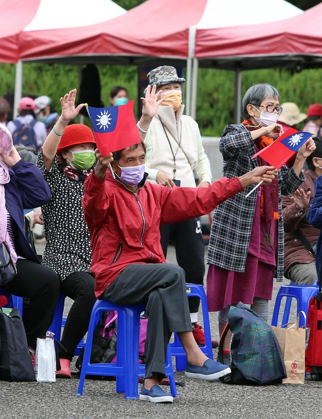 现场举行的辛亥市集国父诞辰纪念公益园游会，与会民眾开心在台下看着演出挥舞国旗。（赵双杰摄）