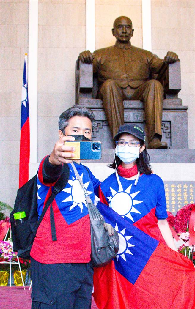 身穿国旗装的民眾12日前往台北国父纪念馆，为孙中山156周年诞辰纪念日致意，并与国父铜像合影留念。（罗永铭摄）