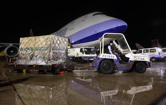 貨機停妥後地勤人員立即卸下裝載疫苗的冷凍貨櫃。（范揚光攝）