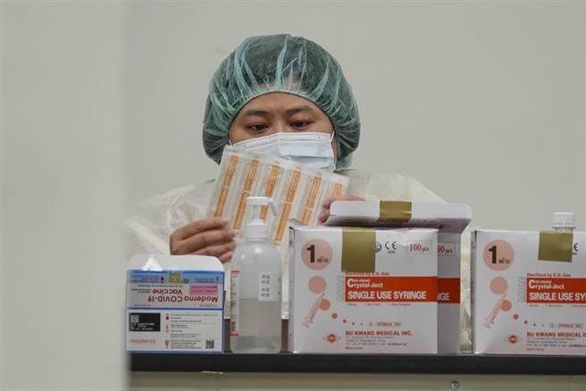 國內疫苗到貨量充足，雖然適逢周六假期，台北市成德市民活動中心接種站13日仍為市民提供服務，不少民眾前往施打莫德納疫苗，負責分裝疫苗護理人員專注執行作業。（黃子明攝）（圖中非新聞當事人）
