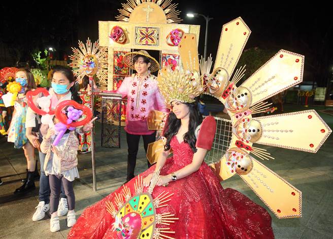 新移民朋友穿上亮丽的环保服饰，并与民眾合影。（张铠乙摄）