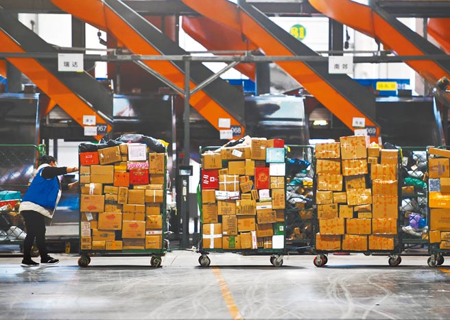 雙11物流高峰，物流公司增加人力投入，工作人員加緊將各類商品分揀、裝車、配送，保障快遞物品及時送達。 （新華社）