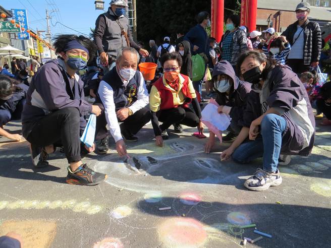 朝元宫主委尤碧铃（中）与龙津高中学生一起彩绘妈祖。（王文吉摄）