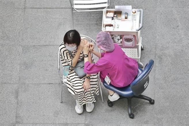 民眾施打高端疫苗第2劑時，因為疼痛而縮起身體。（本報資料照片）