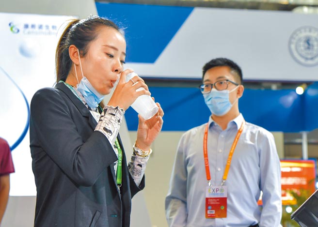 大陆研发的全球首款吸入式腺病毒载体新冠疫苗「克威莎」，12日在海南国际健康产业博览会亮相，一位记者用饮用水体验接种，过程就像喝饮料。（中新社）