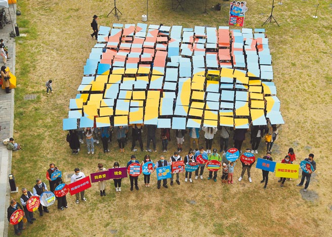 台中市政府经发局13日邀请约200位幸运得主在台中火车站快闪，手拿色板排出蓝底及红、金两色「台中GO」字样，将自身好运分享给大家。（台中市政府提供／陈世宗台中传真）