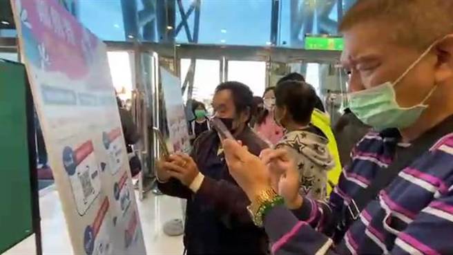 民眾擠在嘉義市購物節兌換現場掃活動官網QRcode。（廖素慧攝）