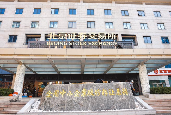 北京证券交易所于今（15）日开市，14日北京金融街上，施工人员在北交所办公大楼进行门牌吊装和焊接工作。（中新社）