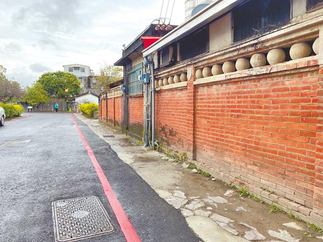 新竹县北埔老街去年施作电缆地下化工程，原先石板铺面如今以柏油取代，并在古蹟周边画上红线，遭居民批评「没有美感」、隔出与古蹟的距离。（庄旻静摄）