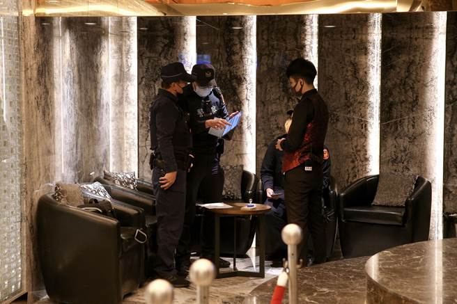 警方针对酒店工作人员进行身分确认及防疫措施检查。（黄世麒摄）