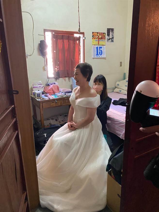 吴奶奶选了削肩款婚纱，造型师为她化妆时，数度激动泛泪。（王文吉摄）